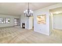 Spacious living room with a decorative chandelier, fireplace, and view into the adjacent kitchen at 4043 Oak Trail Dr, Indianapolis, IN 46237