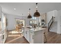 Open-concept kitchen features an island, stainless steel appliances, and flows into a living room with a fireplace at 5387 Citadel Dr, Noblesville, IN 46062