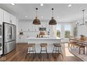 Bright kitchen features a large island with pendant lights, modern appliances, and wood-look flooring at 5387 Citadel Dr, Noblesville, IN 46062
