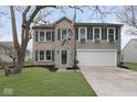 Two-story home featuring brick and vinyl siding, a two-car garage, and green shutters at 5869 Jamestown Square Ln, Indianapolis, IN 46234