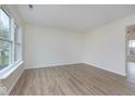 Bright, open living room with wood-look floors and a large window at 5869 Jamestown Square Ln, Indianapolis, IN 46234