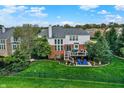 Spacious backyard features a well-maintained lawn, a wooden deck with outdoor seating, and mature trees at 6110 Tanana Dr, Carmel, IN 46033