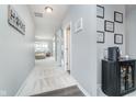 Hallway featuring hardwood flooring, neutral paint, and decor. Leads to a living space with lots of natural light at 726 Jefferson Park Dr, Pittsboro, IN 46167