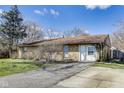 Quaint one-story home with a brick exterior and a convenient driveway on a sunny day at 7906 E 21St St, Indianapolis, IN 46219