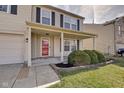Inviting home exterior with a covered porch, neat landscaping, and a welcoming red front door at 8316 S Swimming Hole Ln, Pendleton, IN 46064
