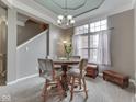 Cozy dining area with a chandelier, a round table, upholstered chairs, and a large window at 834 Bristle Lake Dr, Brownsburg, IN 46112