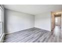 Bright living room featuring gray walls, wood-look floors and a large window providing ample natural light at 9525 Meadowlark Dr, Indianapolis, IN 46235