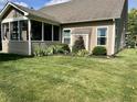 Well maintained lawn, partial view of screened-in porch with decorative landscaping adjacent to the house at 9752 Brook Wood Dr, McCordsville, IN 46055