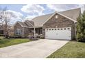 Charming single-Gathering home features beautiful landscaping and a welcoming two-car garage at 9752 Brook Wood Dr, McCordsville, IN 46055
