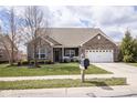 Inviting single-Gathering home with a well-manicured lawn and an attached two-car garage at 9752 Brook Wood Dr, McCordsville, IN 46055
