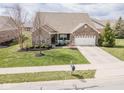 Inviting single-Gathering home with a well-manicured lawn and an attached two-car garage at 9752 Brook Wood Dr, McCordsville, IN 46055