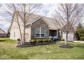 Charming single-Gathering home features beautiful landscaping and a welcoming front porch at 9752 Brook Wood Dr, McCordsville, IN 46055