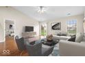 Bright living room featuring hardwood floors, neutral walls, vaulted ceilings, and modern furnishings at 9856 Commonwealth Dr, Fishers, IN 46038