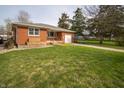 Charming brick home featuring a well-manicured lawn and an attached garage with a side view at 1019 N Lesley Ave, Indianapolis, IN 46219