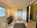 Foyer featuring tile flooring, coat rack, and a sliding barn door at 11522 N 450 W, Alexandria, IN 46001