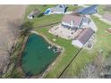 Aerial shot of home featuring a private pond, patio area, and lush green lawn at 1471 S Frog Pond Ct, Greenfield, IN 46140