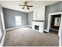 Cozy living room with neutral carpet, gray walls, a white brick fireplace, and a ceiling fan at 316 W 6Th St, Anderson, IN 46016