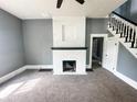 Inviting living room with fireplace, neutral carpet, gray walls, and staircase to the second floor at 316 W 6Th St, Anderson, IN 46016