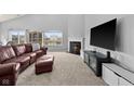 Bright living room with fireplace, leather sofa and ottoman, and big windows with a view at 462 N Crystal Dr, Fortville, IN 46040