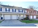 Charming townhome exterior featuring an attached garage, a well-manicured lawn, and tidy landscaping at 4951 Tuscany Ln, Indianapolis, IN 46254
