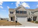Charming two-story home with beige siding, black shutters, and a two-car garage at 5208 Rolling Meadow Blvd, Indianapolis, IN 46237