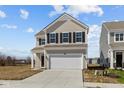 Charming two-story home with beige siding, black shutters, and a two-car garage at 5208 Rolling Meadow Blvd, Indianapolis, IN 46237