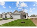 Beautiful gray home with a two-car garage and a freshly planted tree at 5211 Rolling Meadow Blvd, Indianapolis, IN 46237