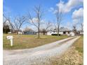 Quaint home with long gravel driveway, mature trees, and a mailbox out front at 5225 S Linwood Ave, Indianapolis, IN 46237