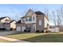 Two-story home featuring a well-manicured lawn, attached two car garage and neutral brick and tan siding at 5607 Regency Dr, Columbus, IN 47203
