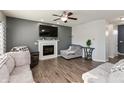 Cozy living room with a fireplace, hardwood flooring, ceiling fan, and comfortable seating arrangement at 5607 Regency Dr, Columbus, IN 47203