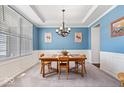 Bright dining room with blue walls, chandelier, wainscoting, and a large window at 5658 Pecan Ct, Noblesville, IN 46062