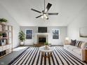 Bright living room features a fireplace, ceiling fan, and stylish black and white striped rug at 603 Raintree Dr, Avon, IN 46123