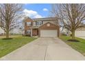 Inviting two-story home boasts a brick and gray exterior, a two-car garage, and a well-manicured lawn at 6916 Cobb Cir, Noblesville, IN 46062