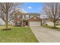 Charming two-story home with a brick and gray siding exterior, two-car garage, and landscaped front yard at 6916 Cobb Cir, Noblesville, IN 46062