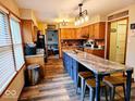 Stylish kitchen features an island with seating and modern lighting, perfect for gatherings and meal preparation at 7231 W Anton Way, New Palestine, IN 46163