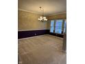 Spacious dining room featuring neutral carpet, chandelier lighting, and large windows at 10072 Graceful Landing Dr, Indianapolis, IN 46234