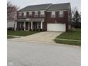 Charming brick home features a two-car garage, well-kept lawn, and mature landscaping at 10072 Graceful Landing Dr, Indianapolis, IN 46234