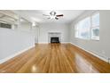 Inviting living room features gleaming wood floors, stone fireplace and a ceiling fan at 1114 S Avon Ave, Avon, IN 46123