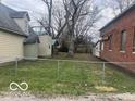 Exterior shot showing grassy backyard with fence separating adjacent building at 11147 Exchange St, Indianapolis, IN 46259