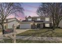 Inviting two-story house with attached garage, seen at dusk with a mailbox showing the street number at 12527 Trester Ln, Fishers, IN 46038