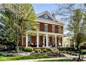 Beautiful brick home featuring a large front porch with columns and professional landscaping at 12897 Queens Troop, Carmel, IN 46032