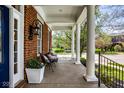 Charming covered front porch with classic columns, seating, and professional landscaping at 12897 Queens Troop, Carmel, IN 46032