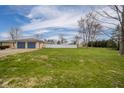 Expansive backyard view, showcasing the vast green space and white fencing, ideal for outdoor activities at 140 Kim Dr, Anderson, IN 46012