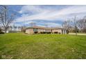 Well-maintained ranch-style home on a large green lot with mature trees and an attached garage at 140 Kim Dr, Anderson, IN 46012