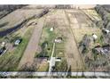 Expansive aerial view of a property featuring multiple buildings, fenced land, and picturesque surrounding fields at 1636 N County Road 425 E, Avon, IN 46123