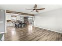 Bright, open-concept living room with wood flooring and a ceiling fan adjacent to a kitchen with white cabinets at 1636 N County Road 425 E, Avon, IN 46123
