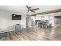 A cozy living room featuring wood flooring, a ceiling fan, and an open-concept design leading to a kitchen area at 1636 N County Road 425 E, Avon, IN 46123