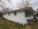 A side view of the home showing vinyl siding, window placement, and front porch at 2194 N Riley Ave, Indianapolis, IN 46218