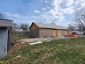 Backyard image showing a house with plywood exterior and a detached garage at 2860 S Rybolt Ave, Indianapolis, IN 46241