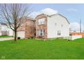 Charming two-story brick and vinyl-sided home with a lush green lawn and mature tree in the front yard at 2885 Holiday Way, Greenwood, IN 46143